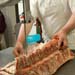 person using a machine to cut meat